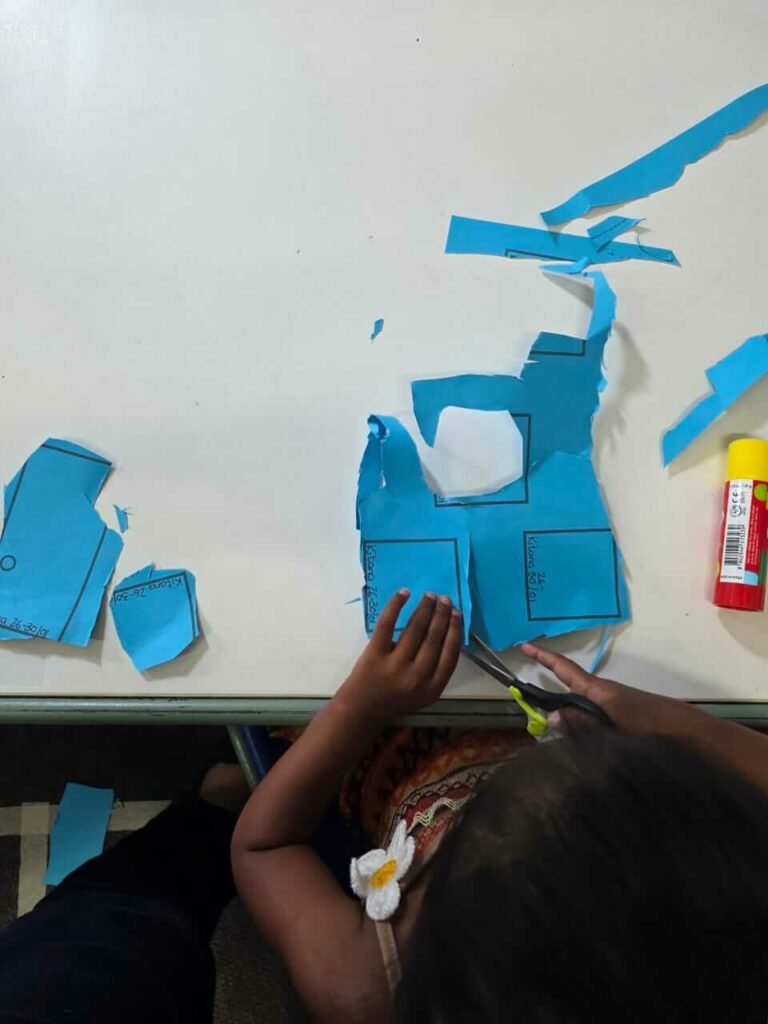 Fine motor scissor skills activity at Petra Christian Pre-School — a young child cutting paper
