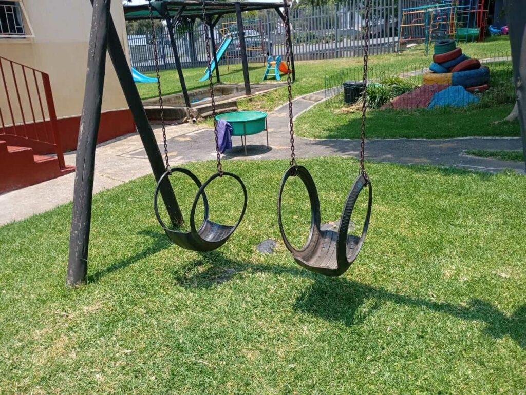 Tyre swings on a black metal swing frame at Petra Christian Pre-School, Edenvale